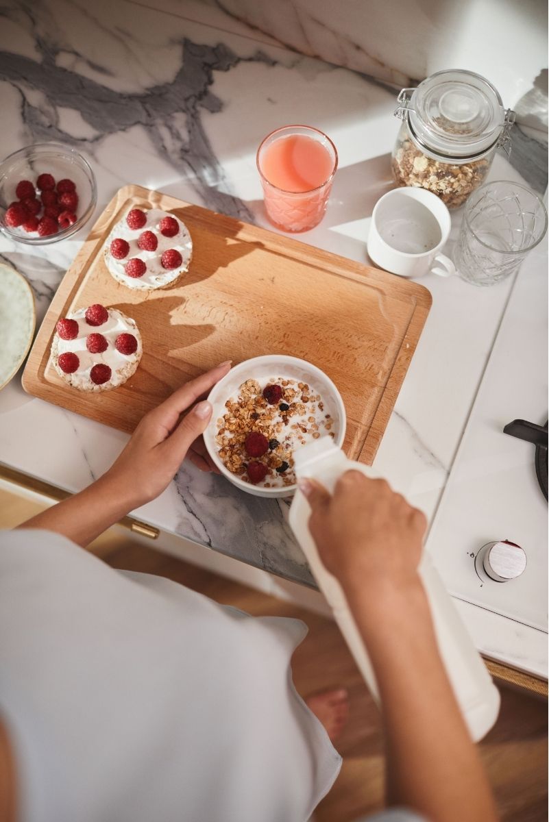 Femme préparant un généreux petit-déjeuner, tout en gourmandise